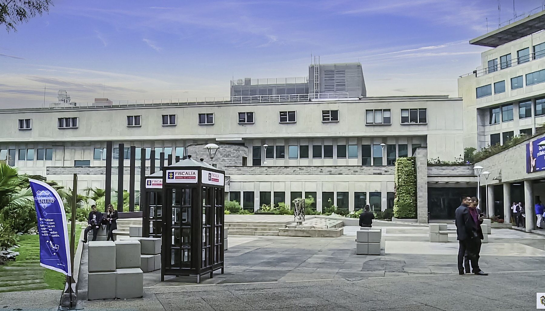 Courtyard of the headquarters of Colombia's Fiscalía General de la Nación, with Fiscalía-branded kiosks and staff outside