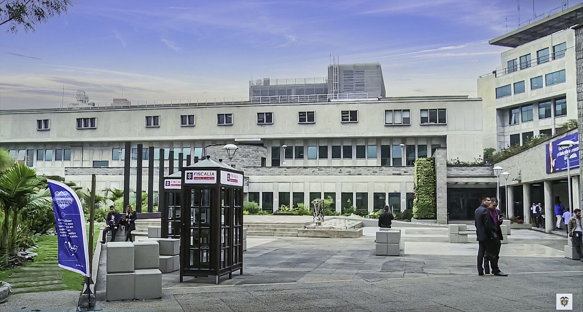 Courtyard of the headquarters of Colombia's Fiscalía General de la Nación, with Fiscalía-branded kiosks and staff outside