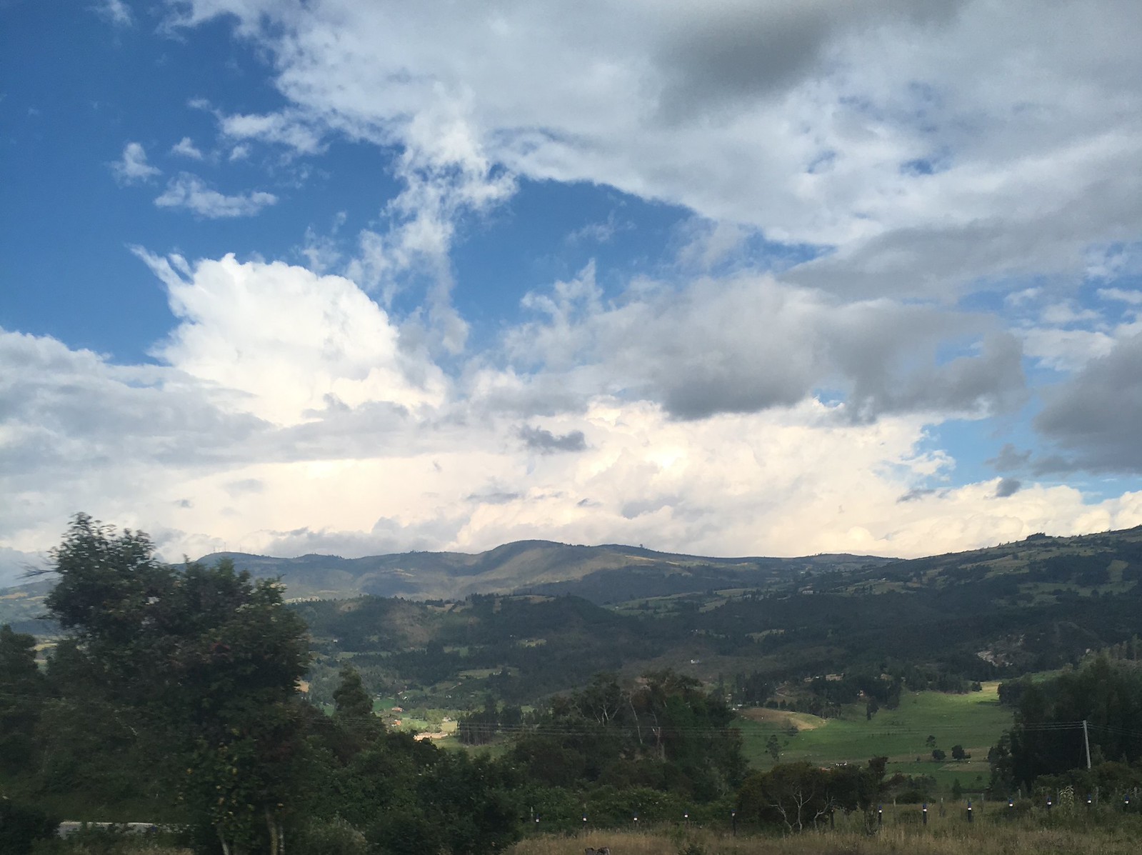 Green hills and farmland under a cloudy sky in Boyacá department, Colombia