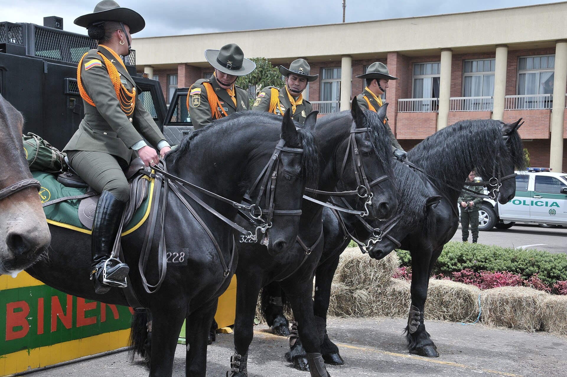 Mounted carabineros of the Colombian National Police beside a police vehicle