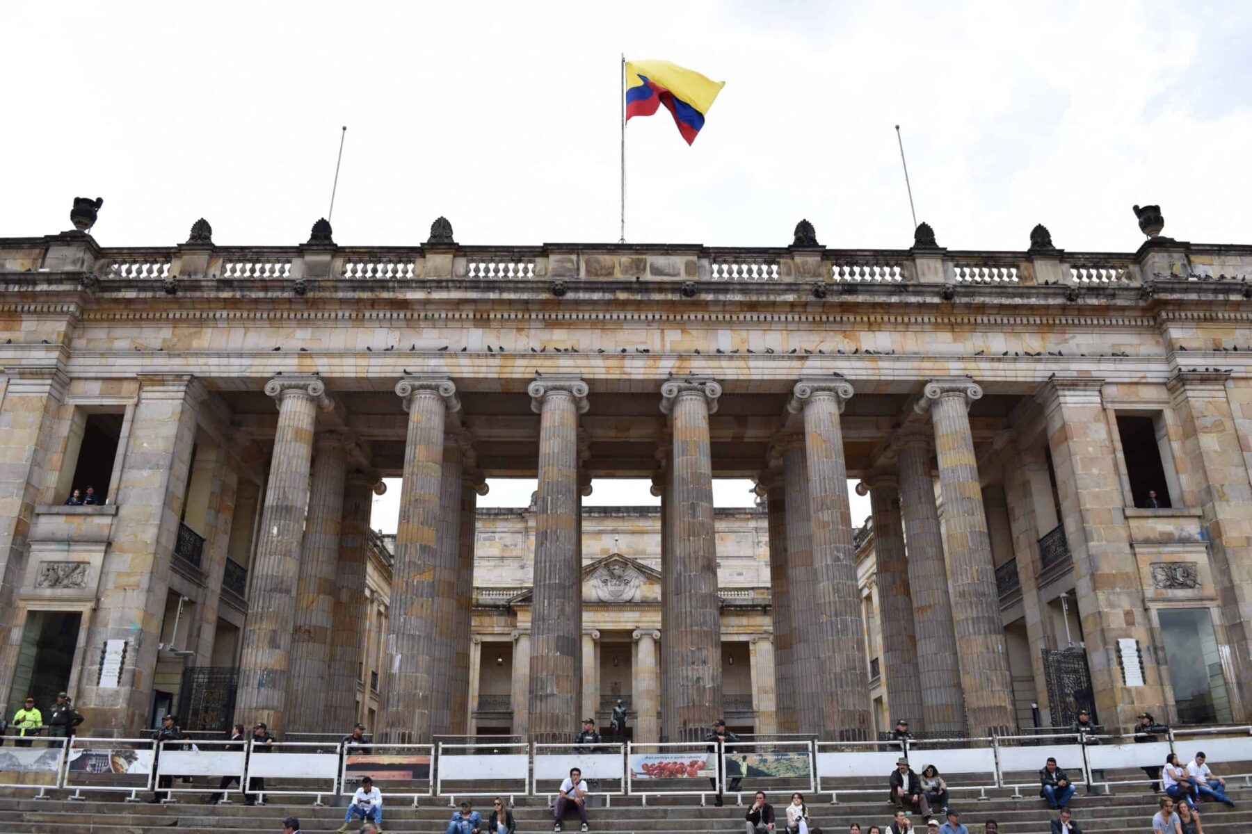 Colombian flag flying above the columned stone facade of the Capitolio Nacional in Bogotá