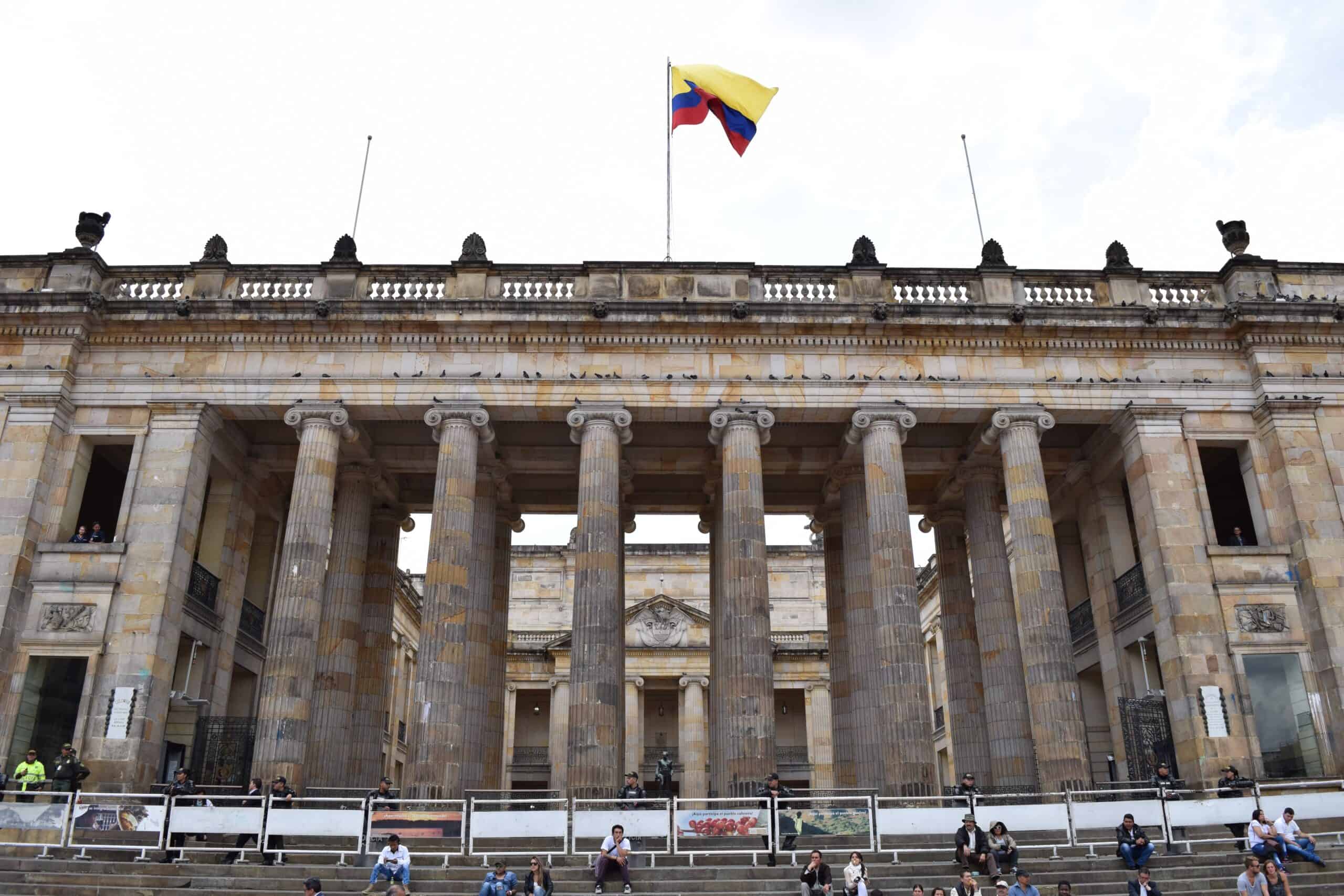 Colombian flag flying above the columned stone facade of the Capitolio Nacional in Bogotá