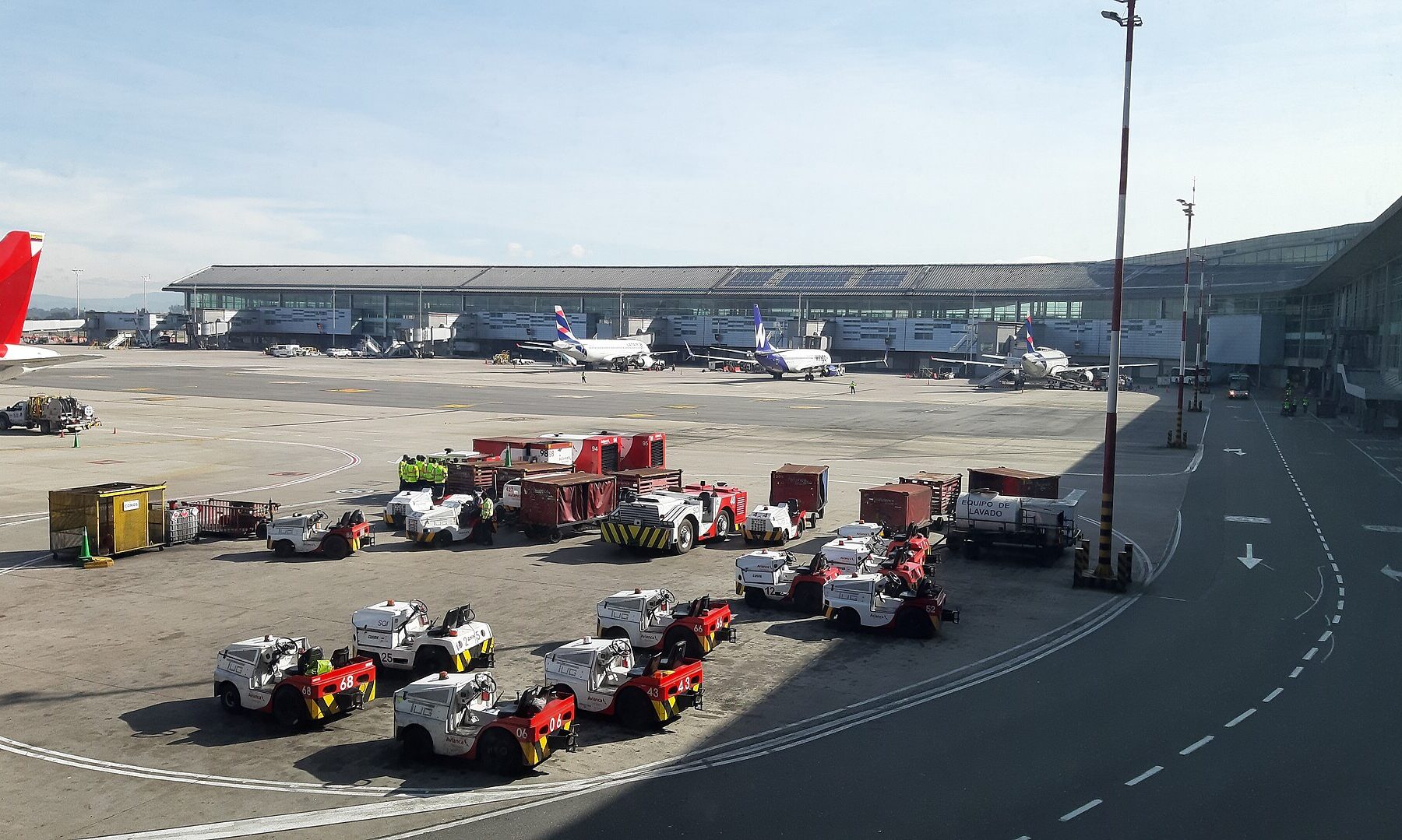 Baggage tractors and aircraft on the apron of El Dorado International Airport in Bogotá, Colombia