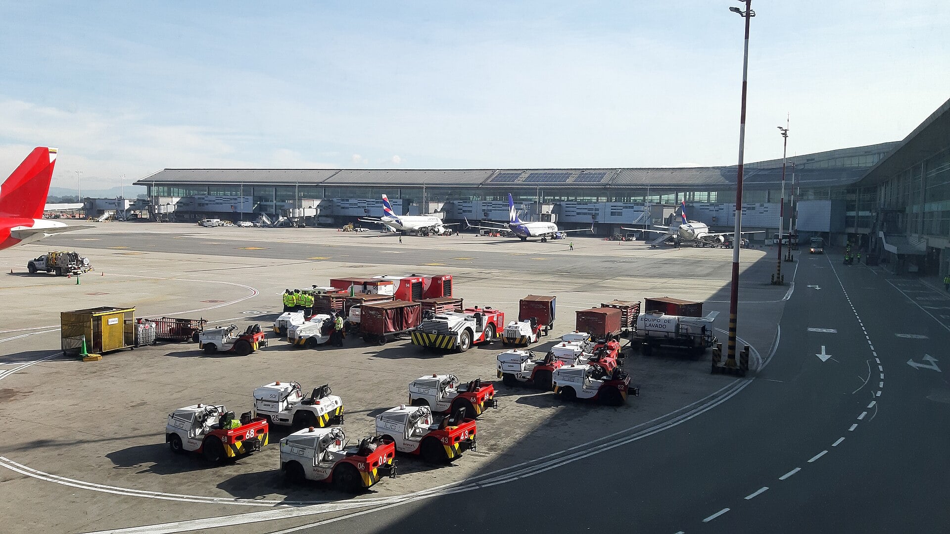 Baggage tractors and aircraft on the apron of El Dorado International Airport in Bogotá, Colombia