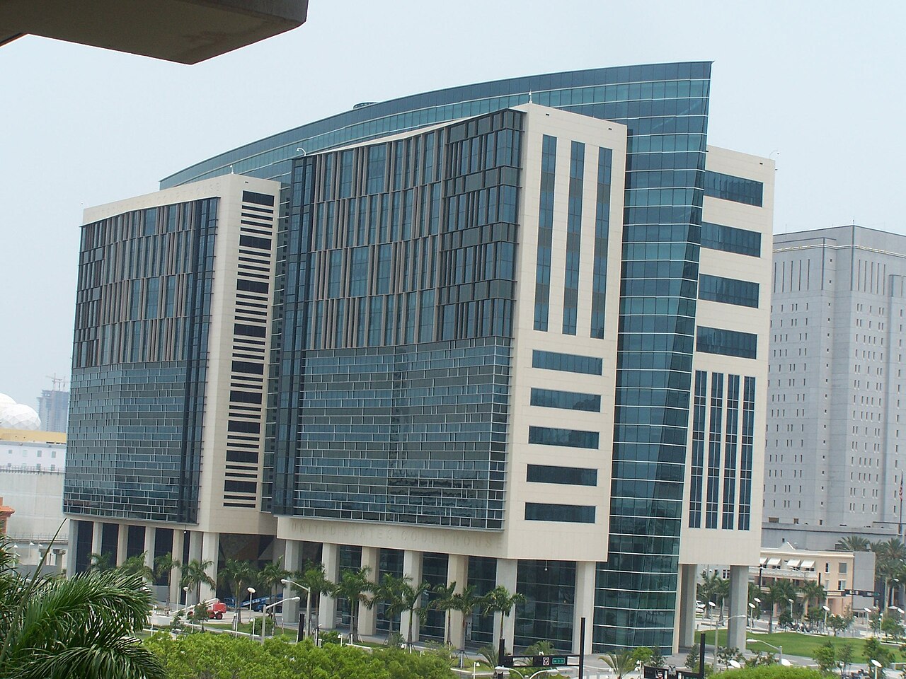 The glass and stone tower of the United States Courthouse in downtown Miami behind palm trees