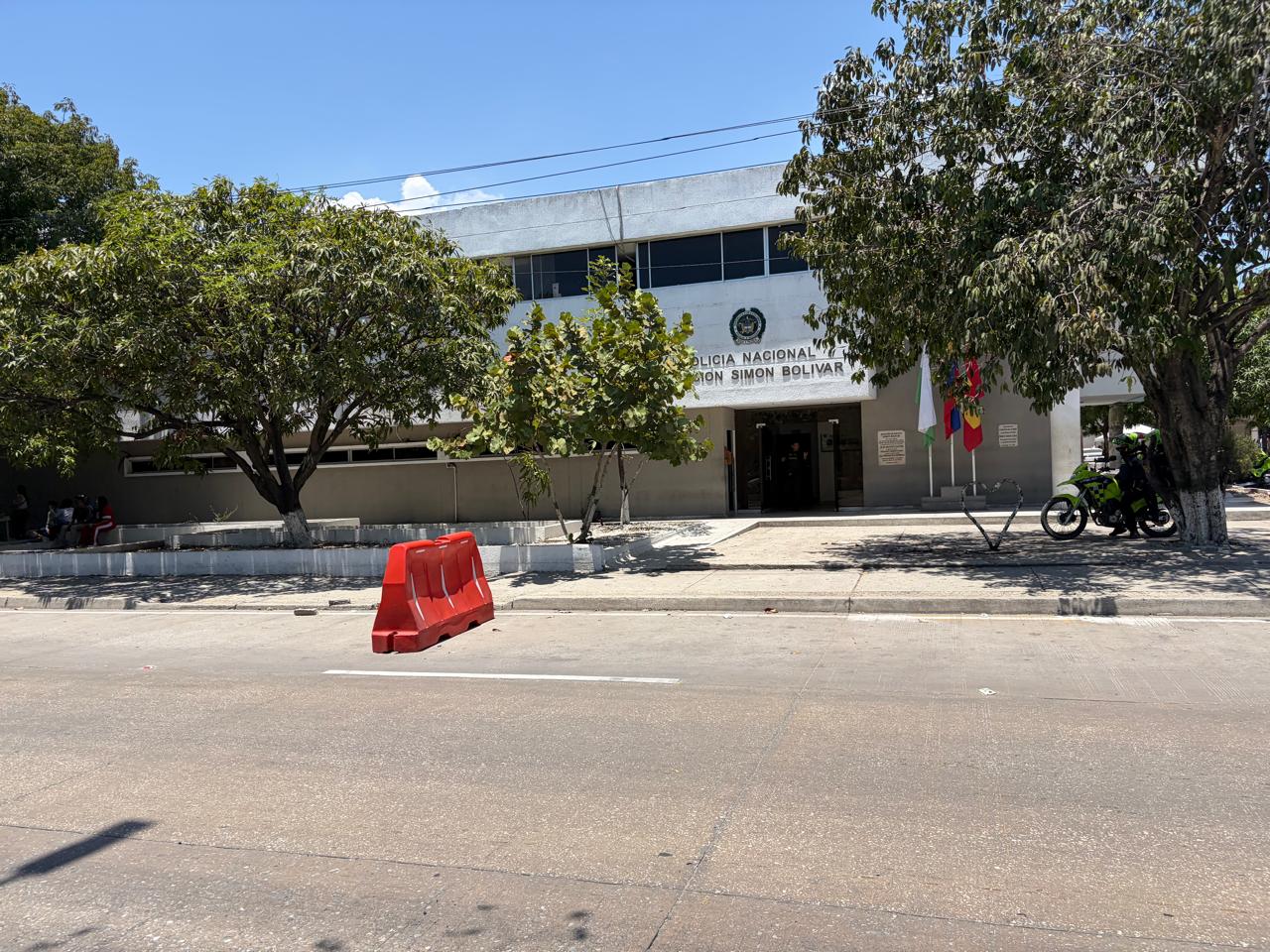 Front of the National Police station in the Simón Bolívar district of Barranquilla, with a police motorbike parked under a tree