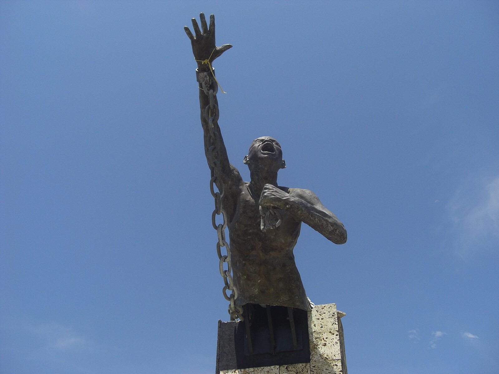 Colombia population: a statue of a chained man raising his arm in San Basilio de Palenque