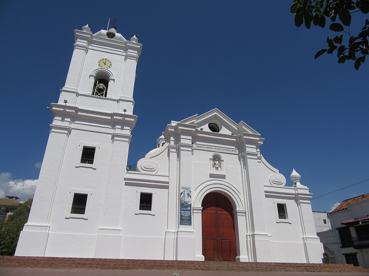 White colonial facade and bell tower of the Basilica Cathedral of Santa Marta under a blue sky