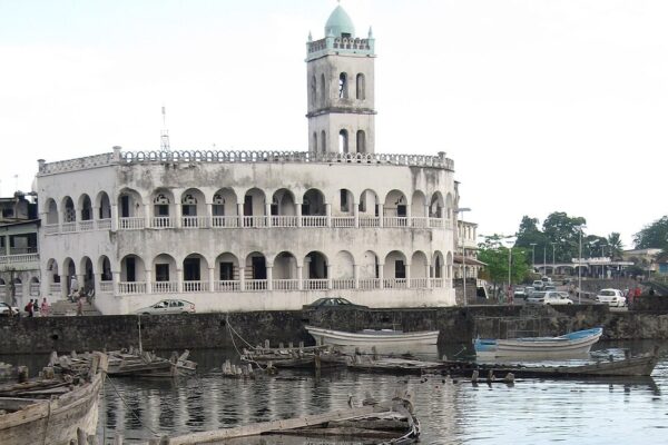 Old Friday Mosque beside the fishing harbour of Moroni, Comoros, with wooden boats in the foreground