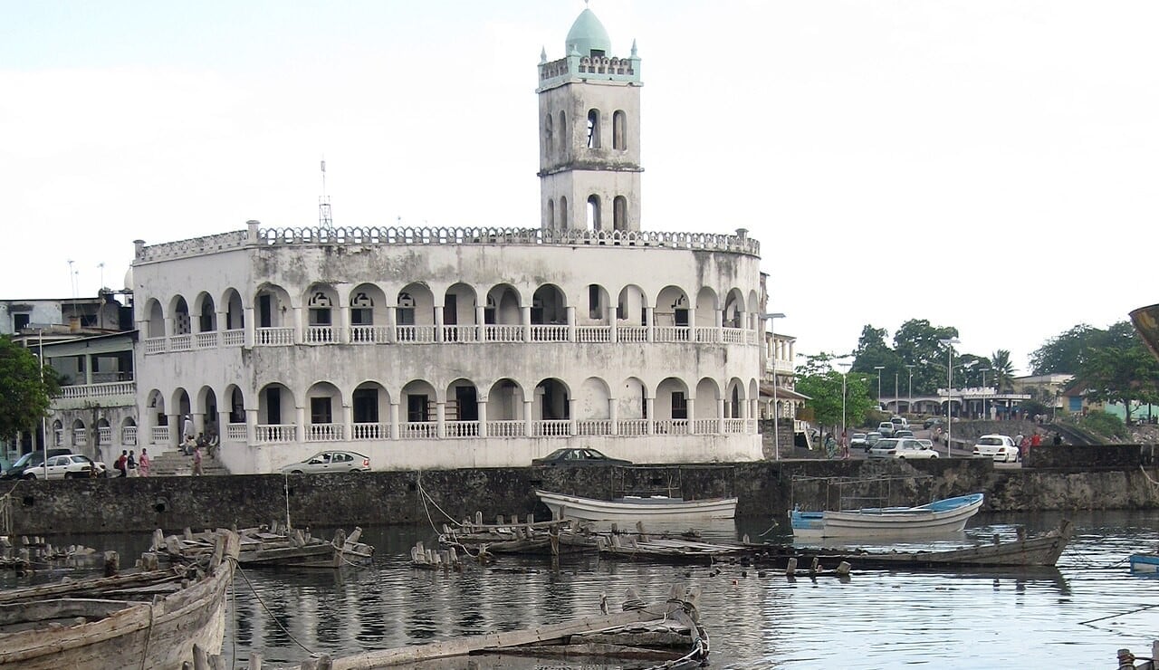 Old Friday Mosque beside the fishing harbour of Moroni, Comoros, with wooden boats in the foreground