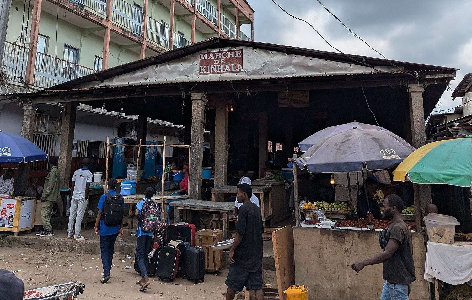 The covered market in Kinkala, capital of the Pool department, Republic of Congo, with traders and shoppers under umbrellas