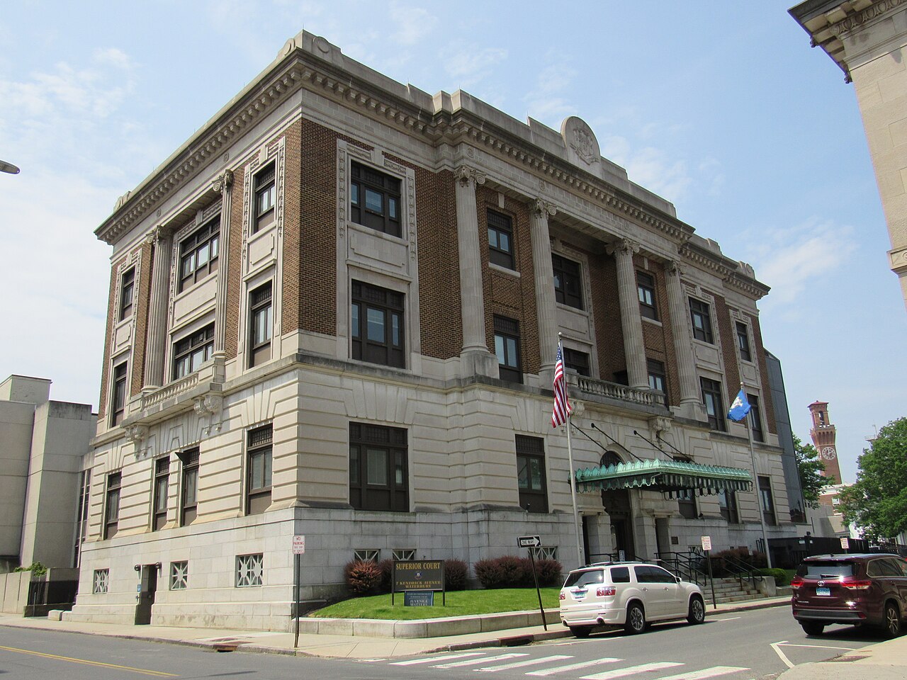 The brick and stone Connecticut Superior Court building in Waterbury, with US and Connecticut flags at the entrance