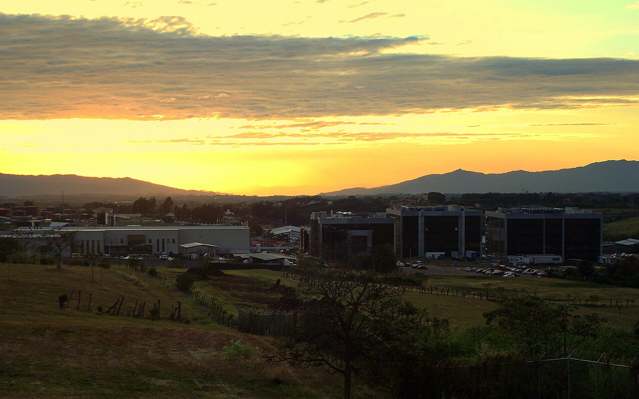 Office and factory buildings of a free-trade zone in Heredia, Costa Rica, at sunset with mountains behind