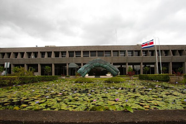 Facade of the Casa Presidencial, the presidential office in San José, Costa Rica, with a lily pond in front and the national flag flying