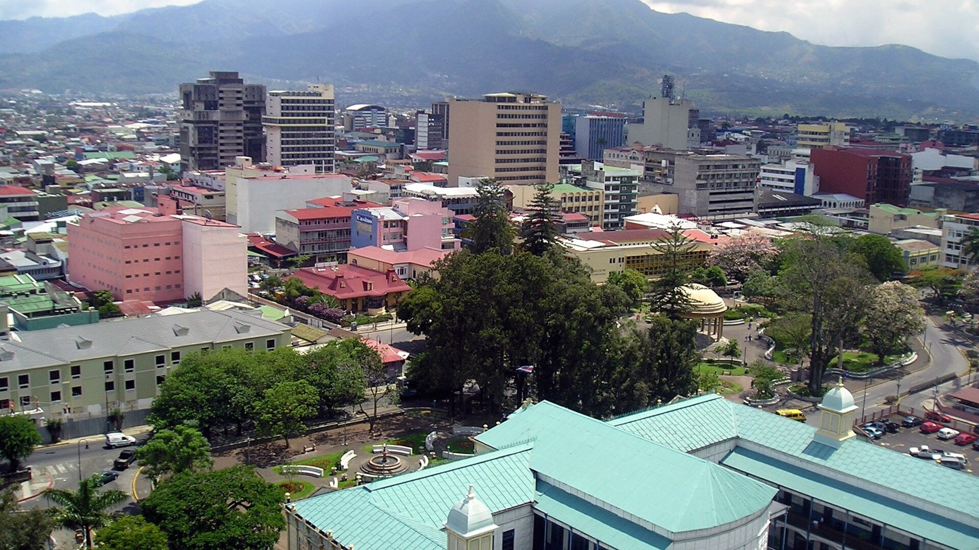 Downtown San Jose Costa Rica with office towers, parks and green roofs below mountains