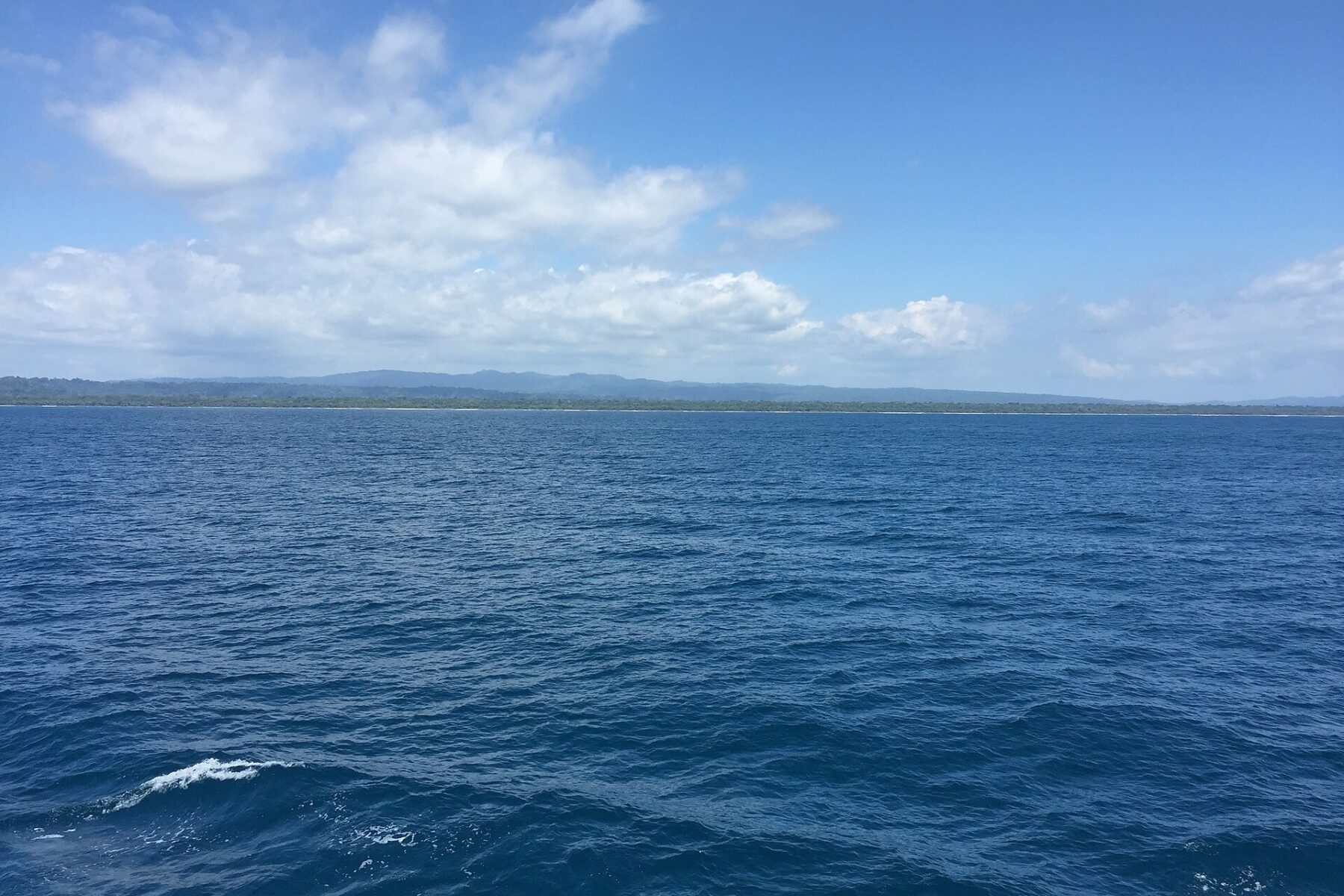 The Pacific Ocean off the Osa Peninsula coast in southern Costa Rica under a partly cloudy sky