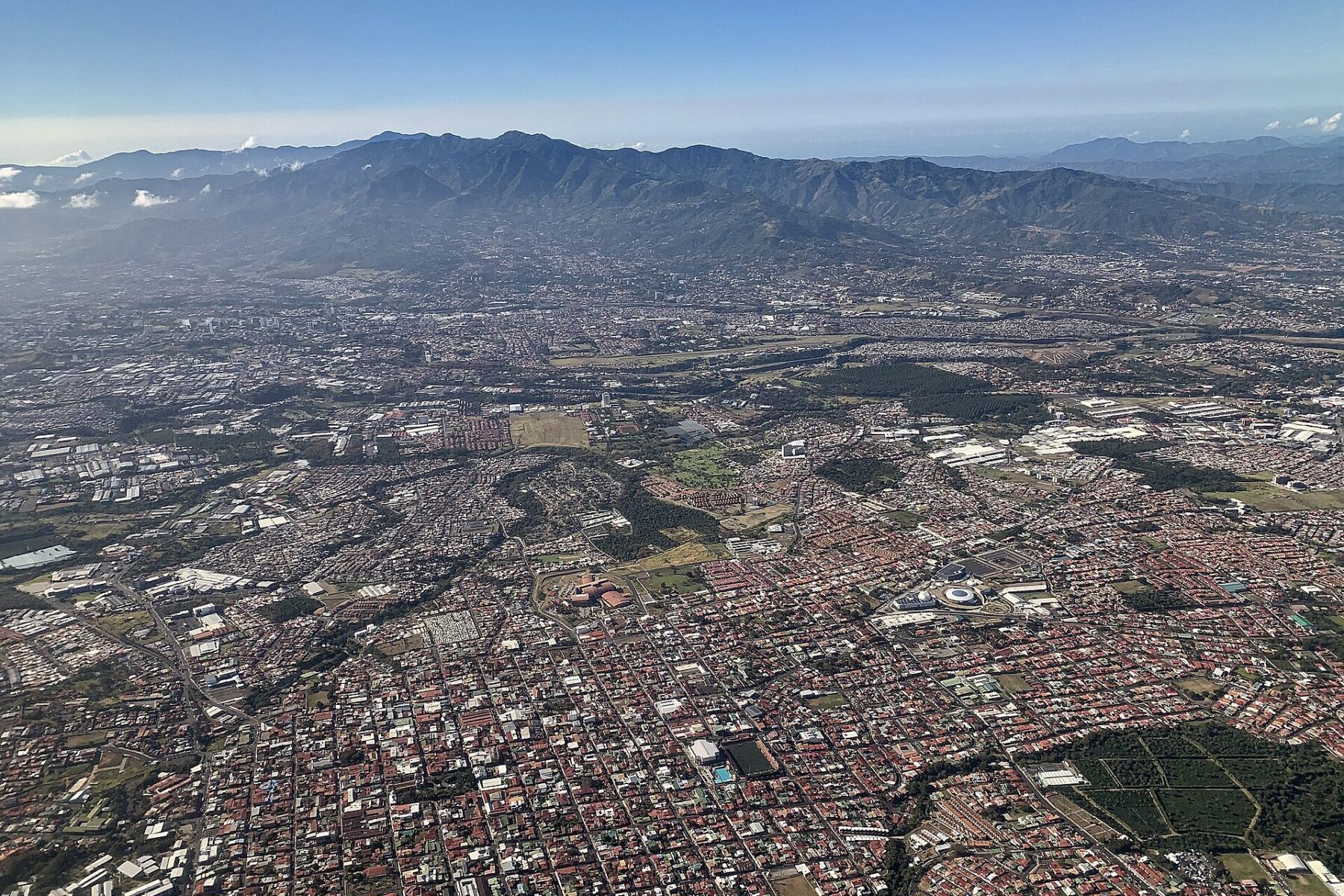 Aerial view of Heredia and the Central Valley of Costa Rica with housing, industrial roofs and mountains in the background