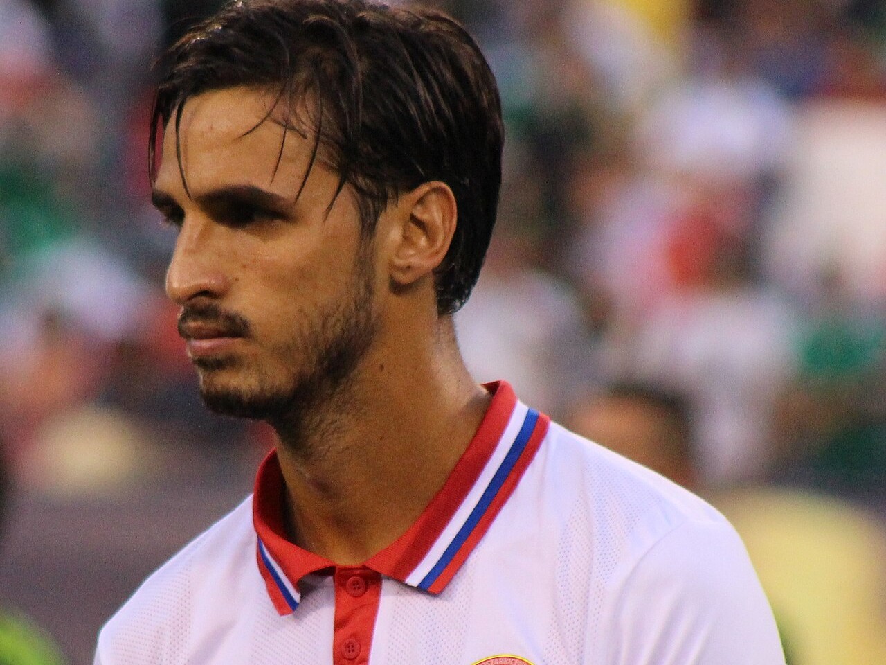 Bryan Ruiz, with dark swept-back hair and a short beard, in Costa Rica's white shirt with a red, white and blue collar