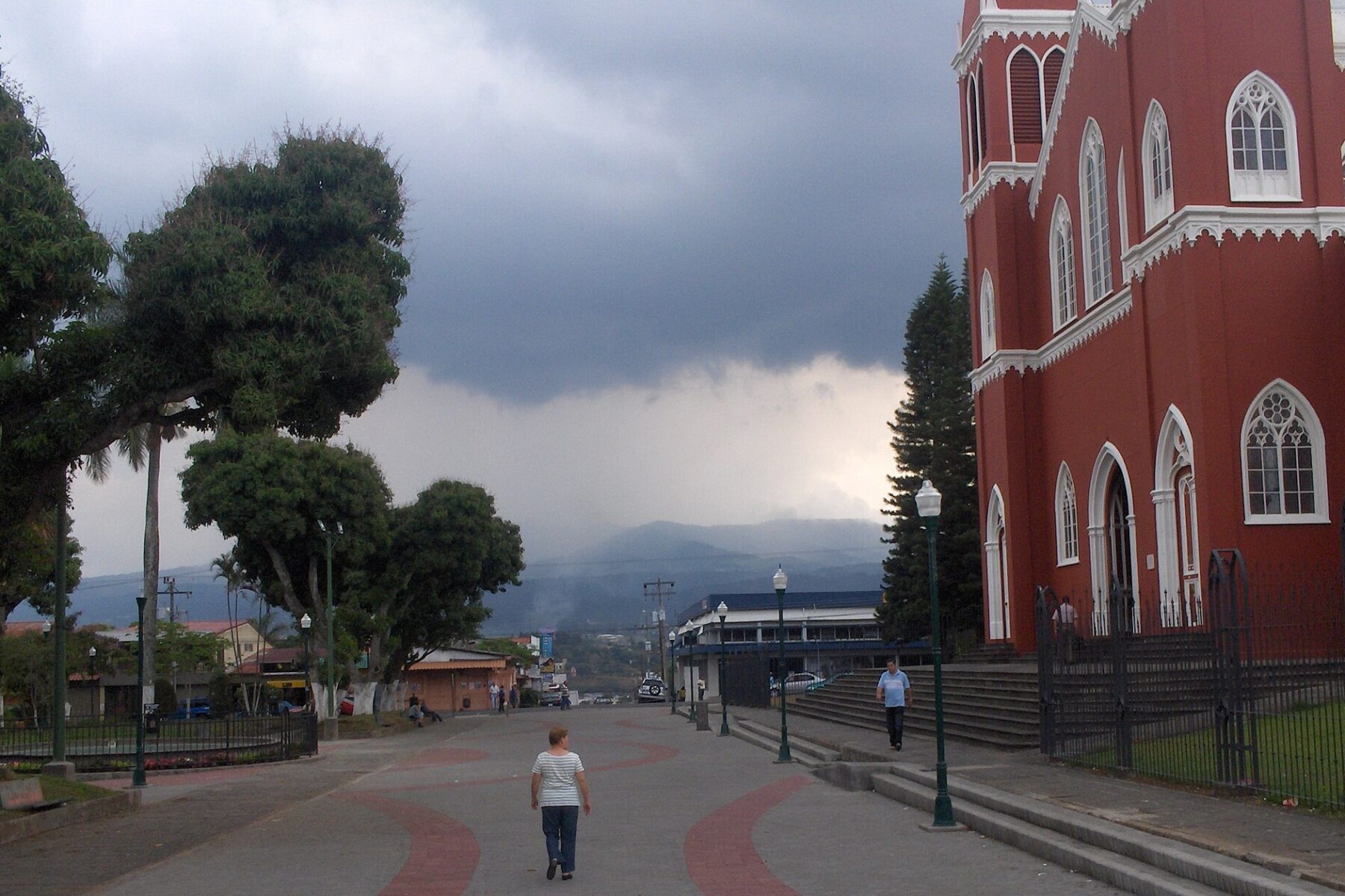 Storm clouds over the central boulevard and red metal church of Grecia, Costa Rica
