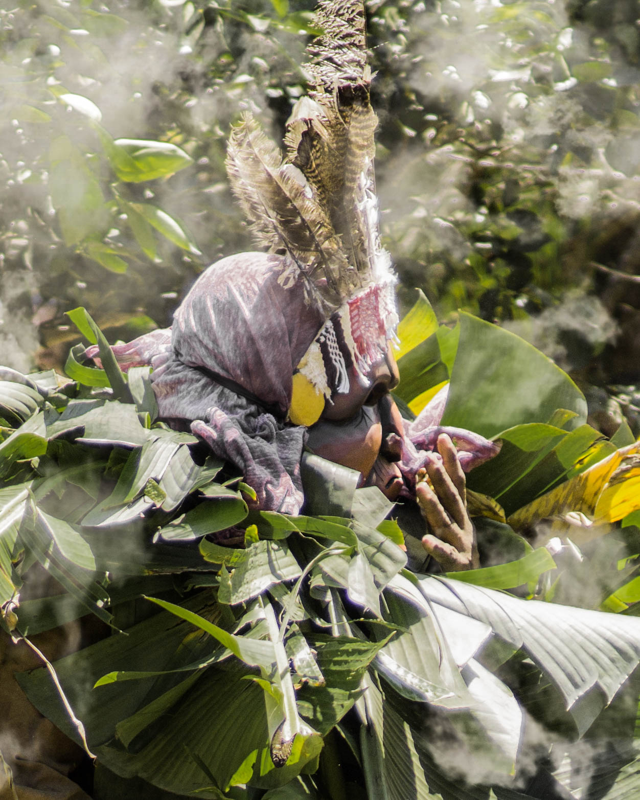 A masked Boruca participant in feathers and banana leaves at the Fiesta de los Diablitos in southern Costa Rica