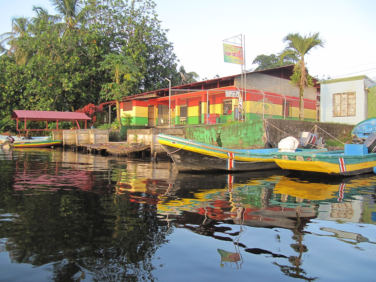 Brightly painted waterfront house and boats on a lagoon on the Caribbean coast of Limón province, Costa Rica
