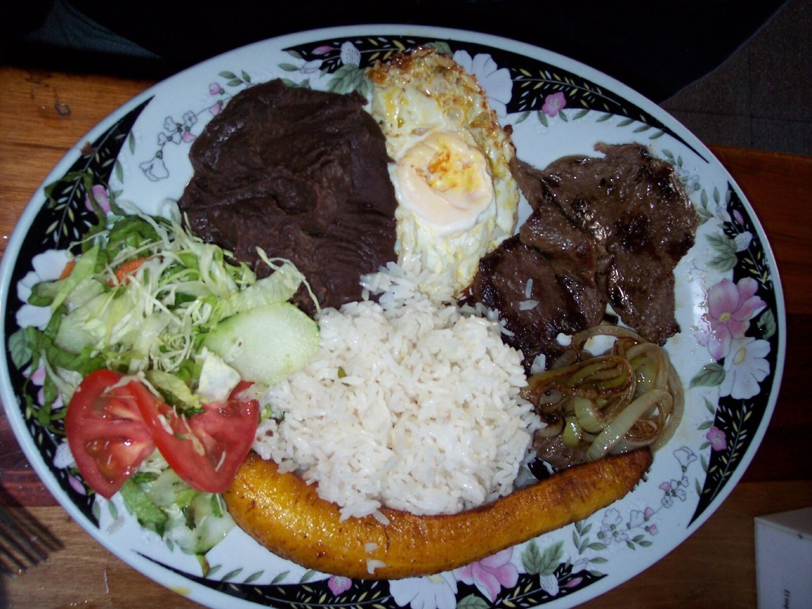 A casado plate of rice, black beans, plantain, salad, egg and beef eaten by Costa Rican people