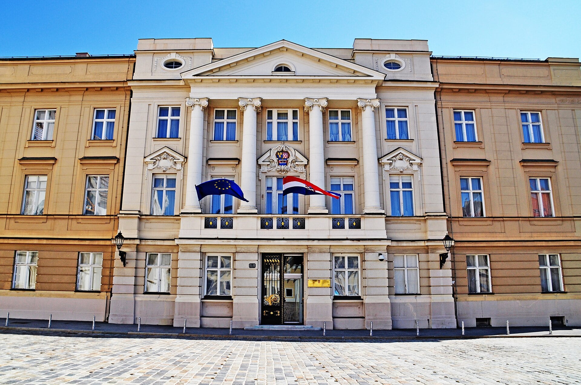 The cream-coloured facade of the Croatian Parliament (Sabor) in Zagreb with the EU and Croatian flags