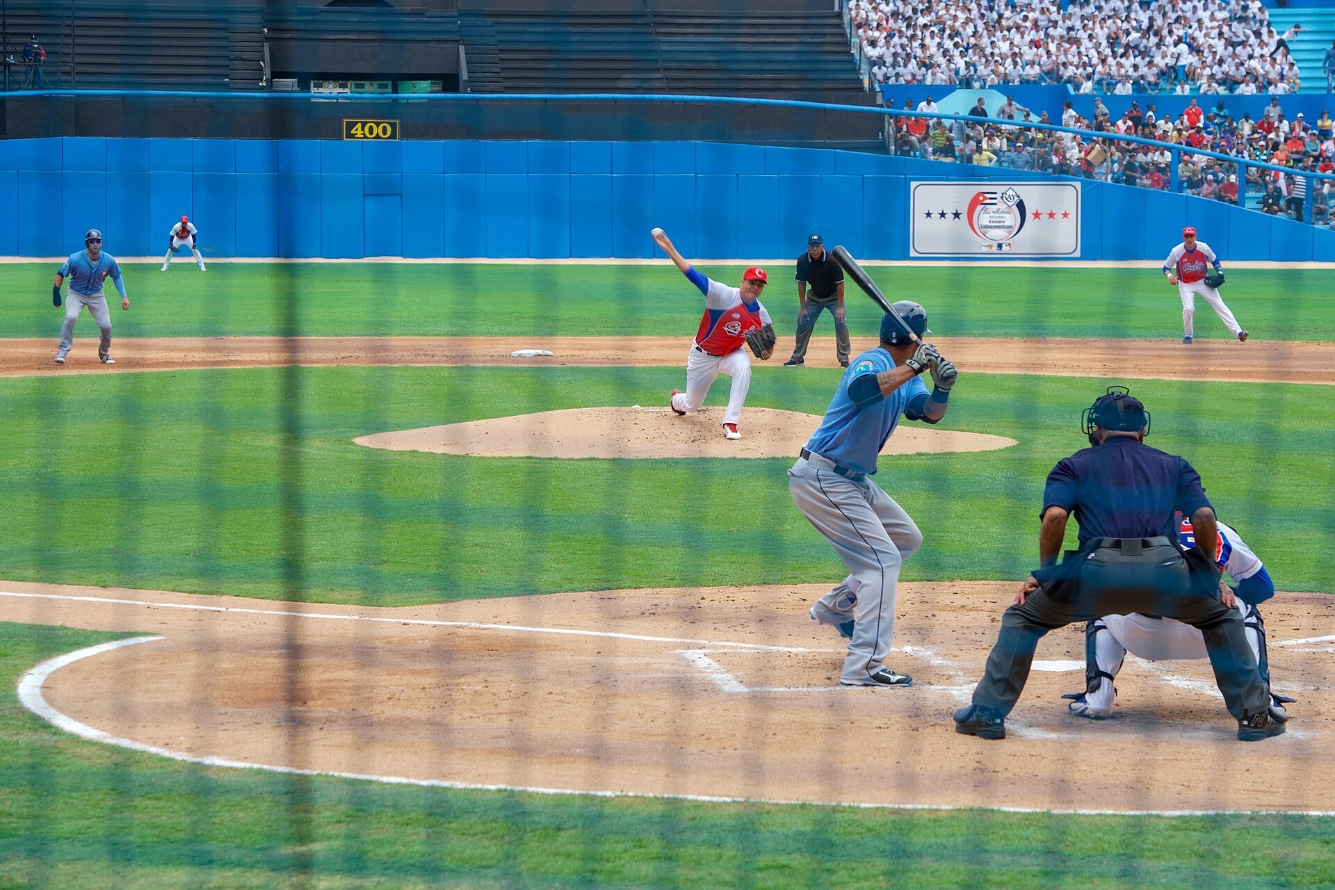 A Cuban national team pitcher throws to a Tampa Bay Rays batter at the Estadio Latinoamericano in Havana with fans in the stands