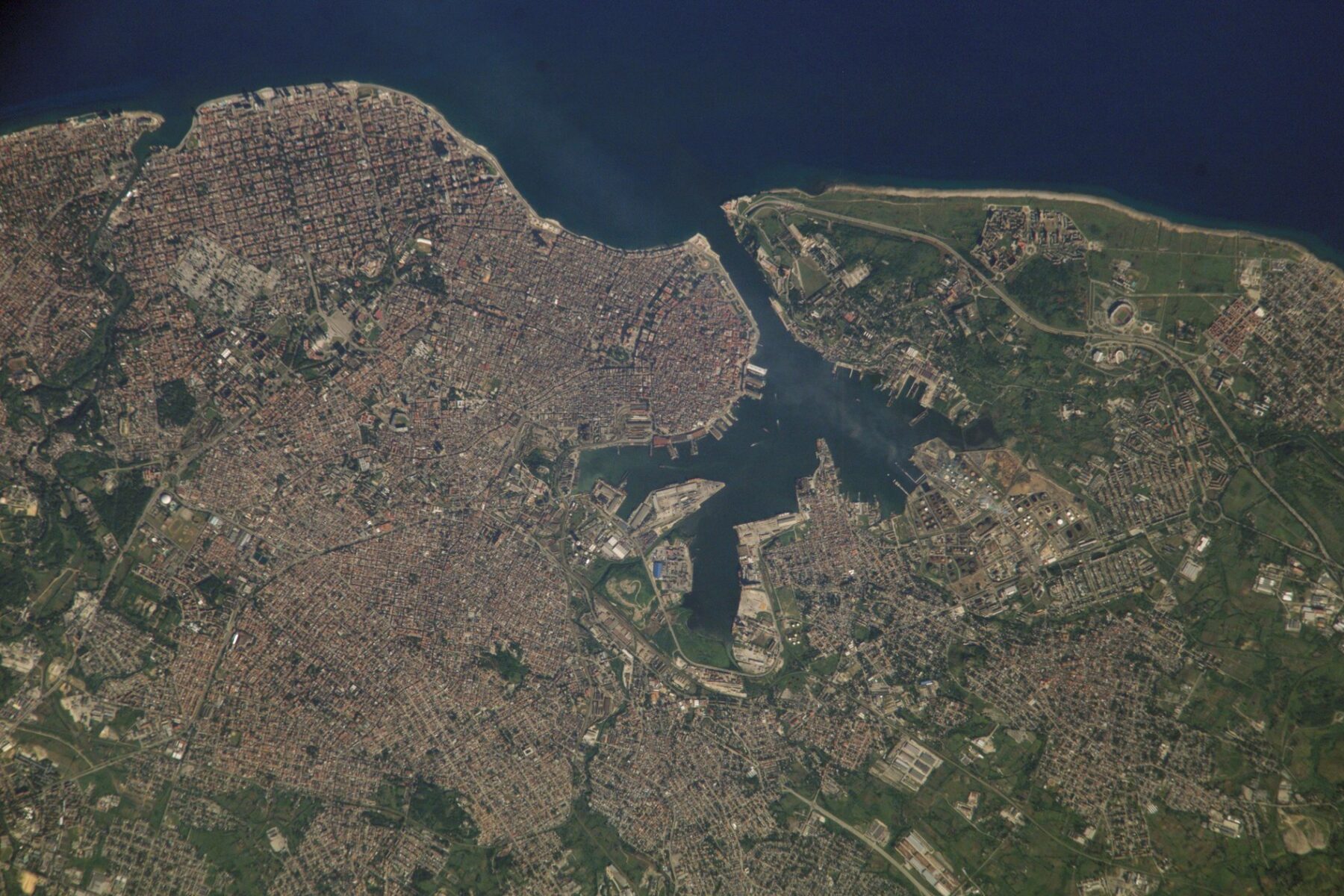 A satellite view of Havana and its bay, with dense city blocks on the left, the harbour in the centre and green hills on the right