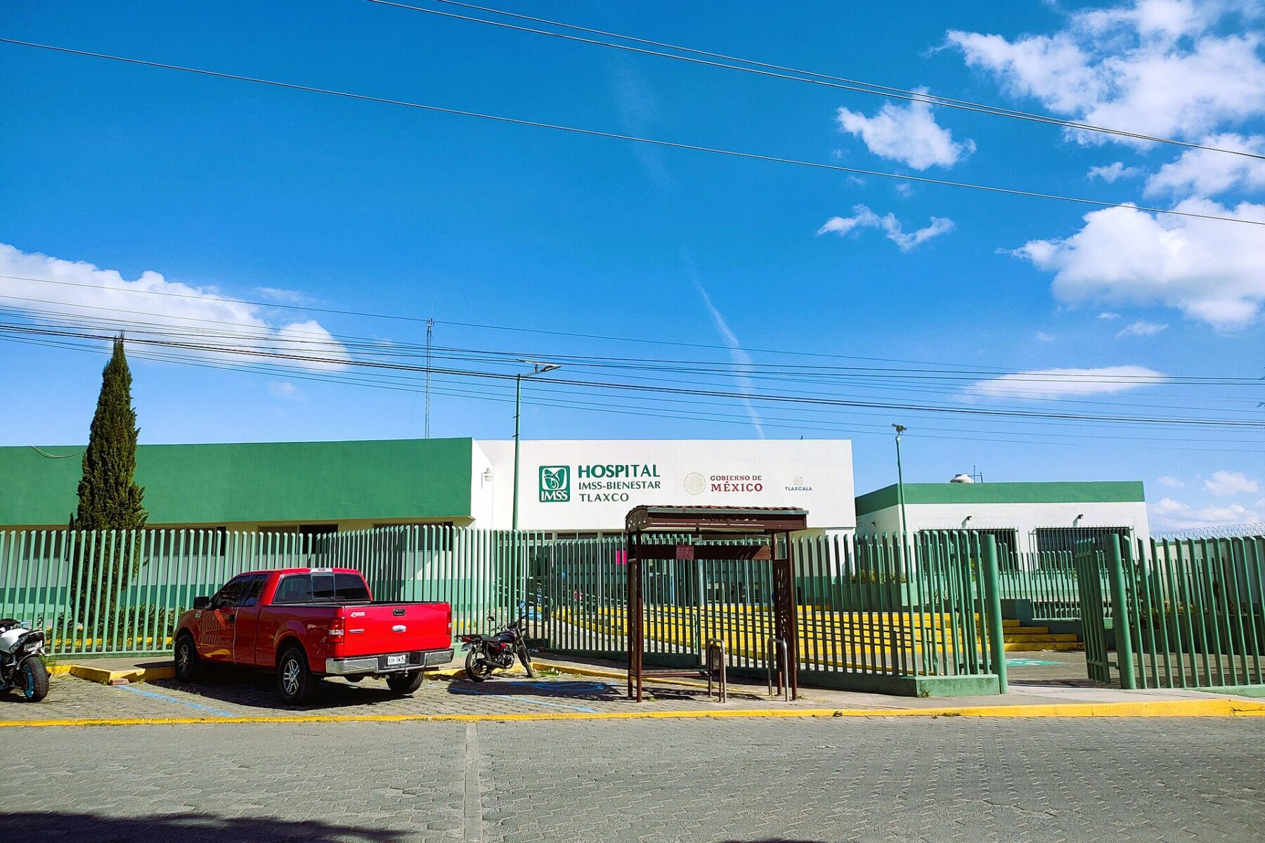 Entrance of the IMSS-Bienestar hospital in Tlaxco, Tlaxcala, Mexico, behind a green fence