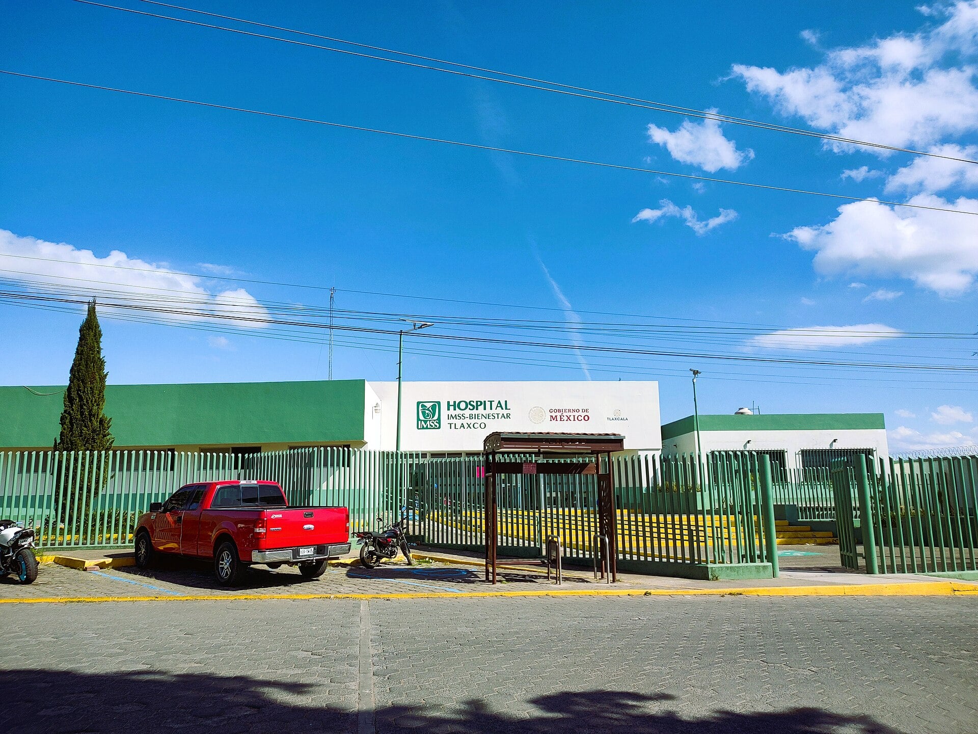 Entrance of the IMSS-Bienestar hospital in Tlaxco, Tlaxcala, Mexico, behind a green fence
