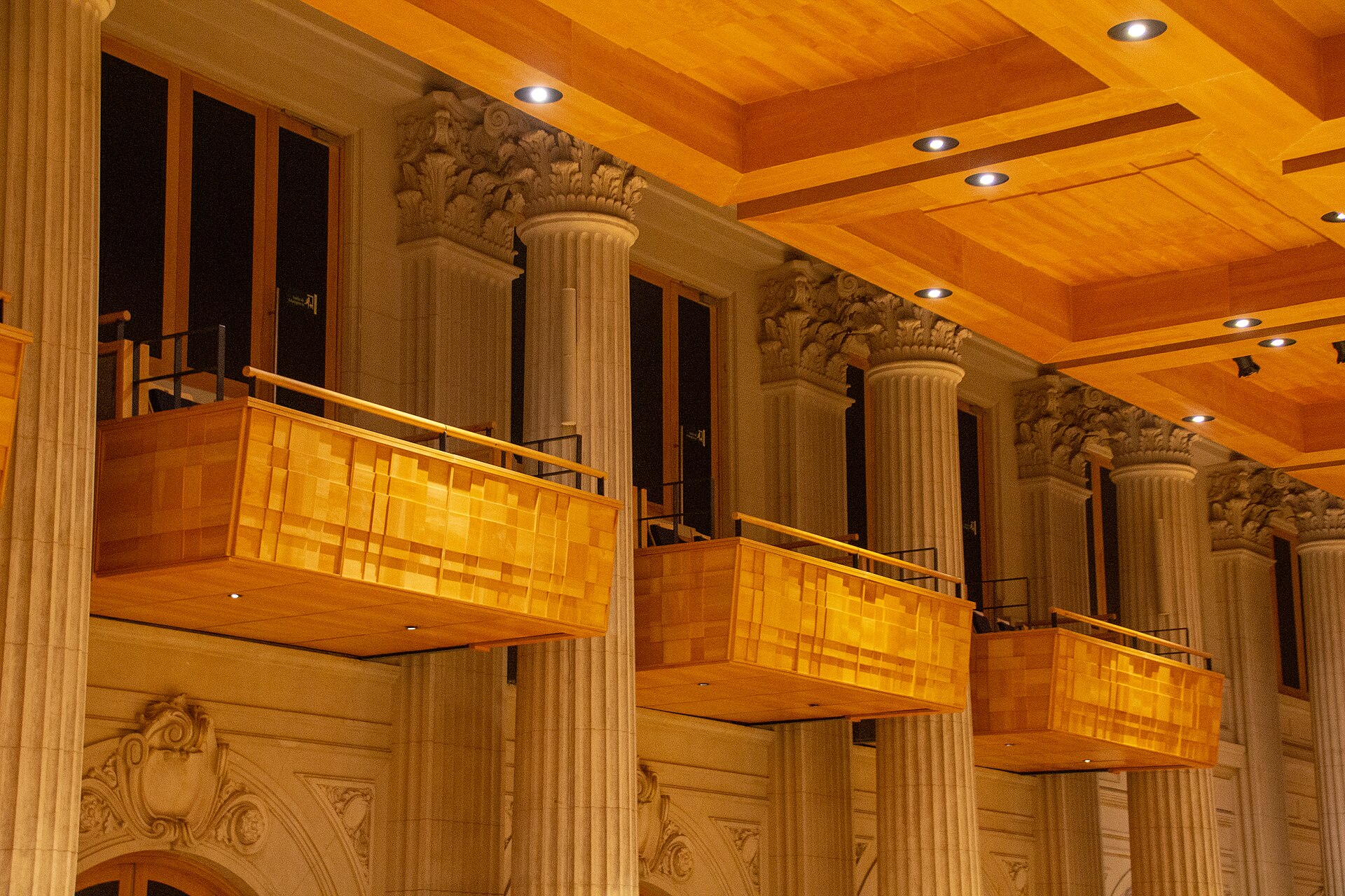 Wood-panelled boxes between stone columns along the side wall of the Sala São Paulo concert hall