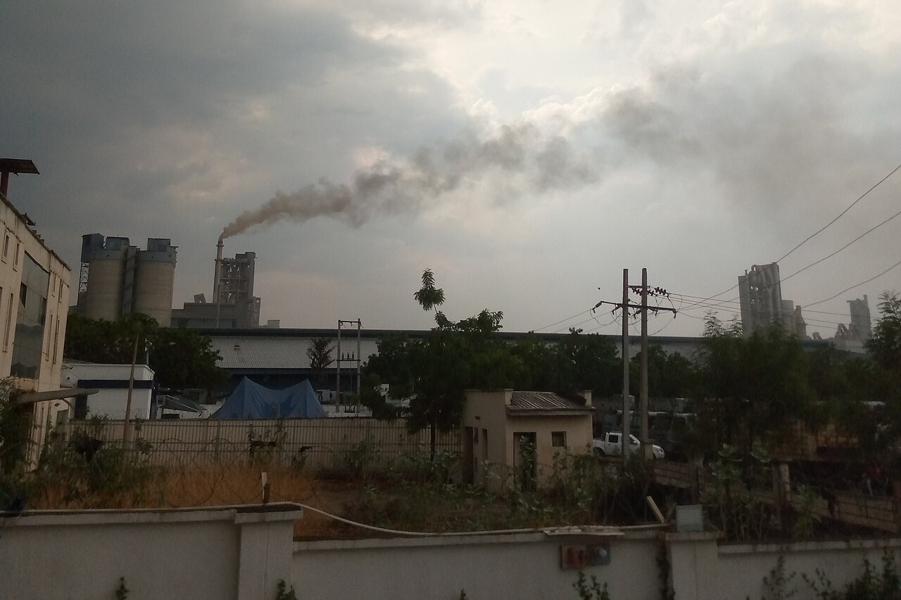 Silos and a smoking chimney at the Dangote cement plant in Obajana, Kogi State, Nigeria, under grey clouds