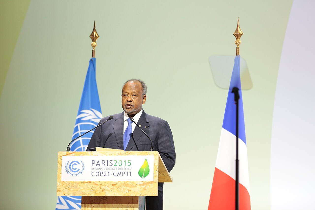 Ismail Omar Guelleh speaking at a lectern between a UN flag and a French flag
