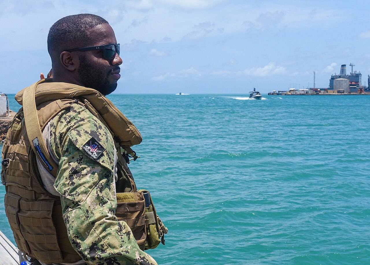 A US Navy sailor on security watch aboard a supply ship looks out over the Port of Djibouti