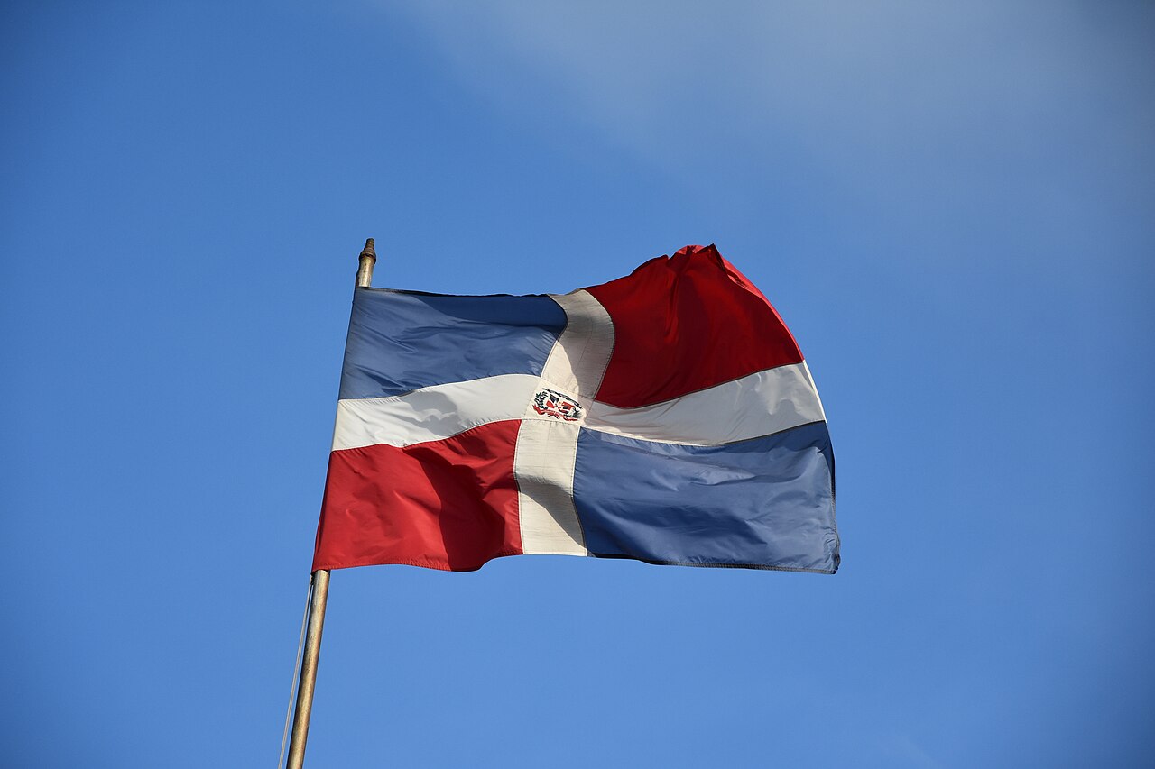 The red, blue and white Dominican flag waves against a clear blue sky