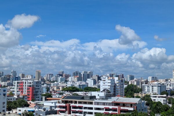 Apartment towers and trees of the La Esperilla district under a blue sky with clouds in Santo Domingo, Dominican Republic
