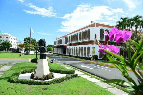 The Listín Diario headquarters in Santo Domingo, with a bust in the front garden, under a blue sky