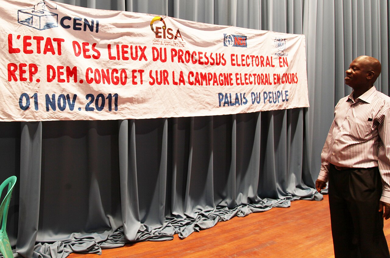 A man looks at a banner on a stage curtain at the Palais du Peuple in Kinshasa, dated 1 November 2011