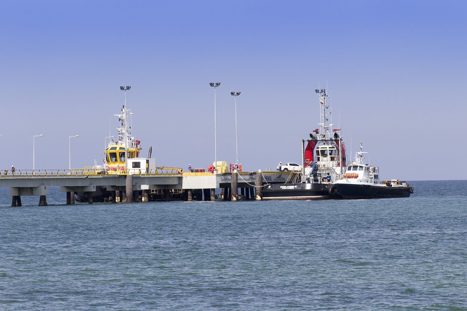 Tugboats moored beside the oil pier at Coveñas on Colombia’s Caribbean coast, with the Ecopetrol name on the pier edge