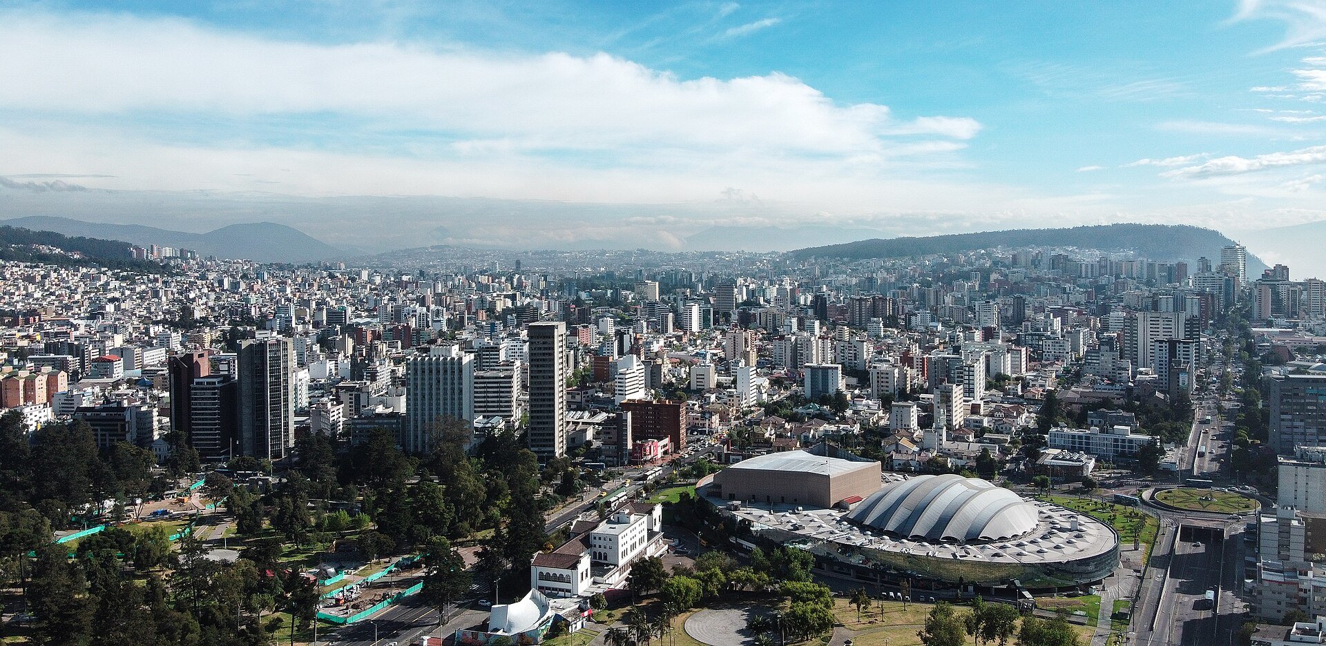 Aerial view of central Quito, Ecuador's capital, with city blocks and Andean hills in the background