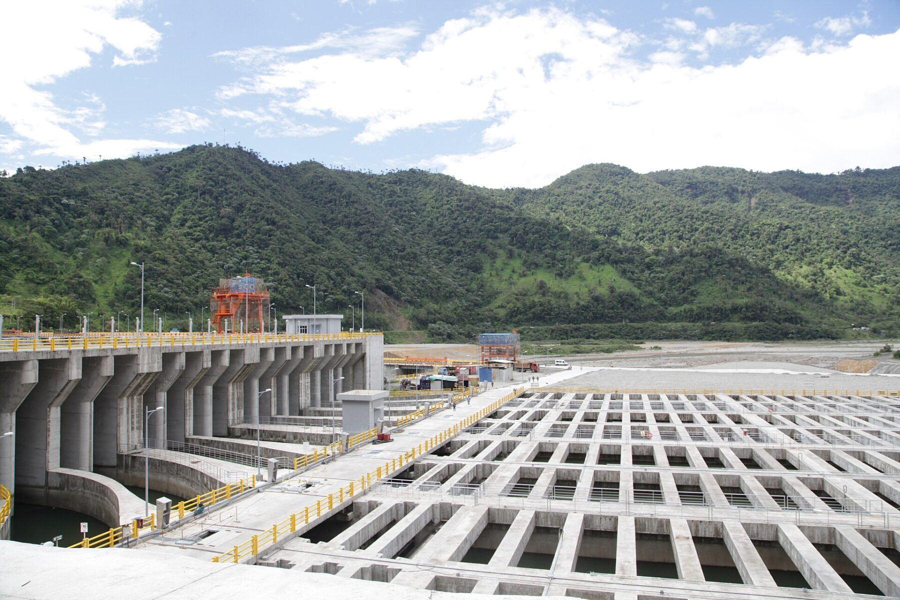Water intake and sediment basins at the Coca Codo Sinclair hydroelectric plant in Ecuador, with forested hills behind