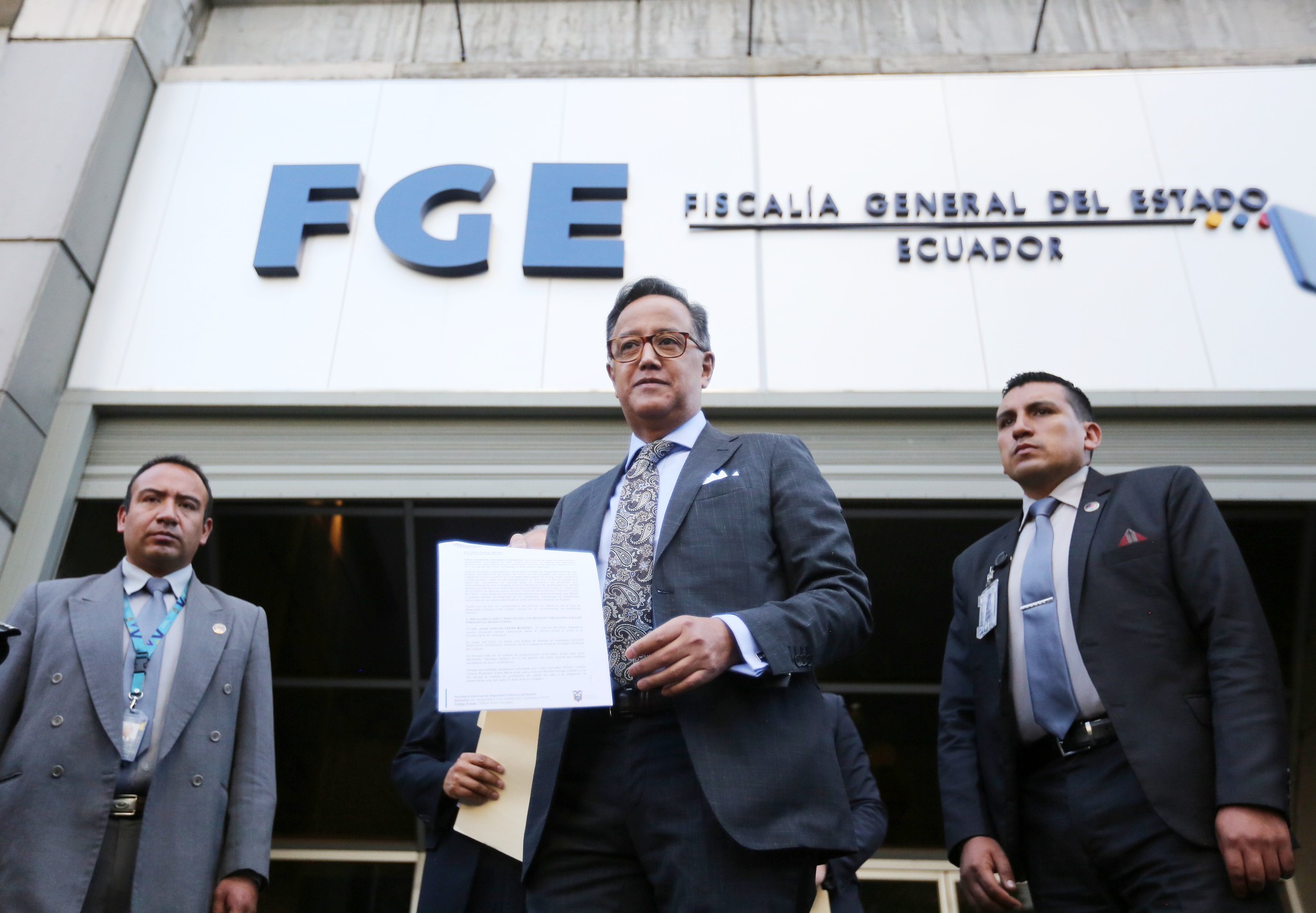 Entrance of Ecuador’s Fiscalía General del Estado in Quito, with officials standing under the FGE sign