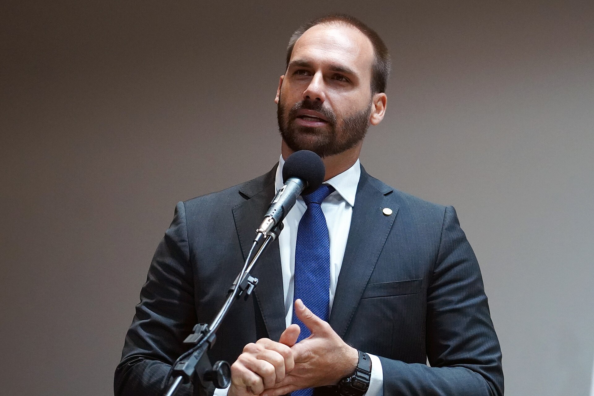 Eduardo Bolsonaro speaking at a microphone in 2019
