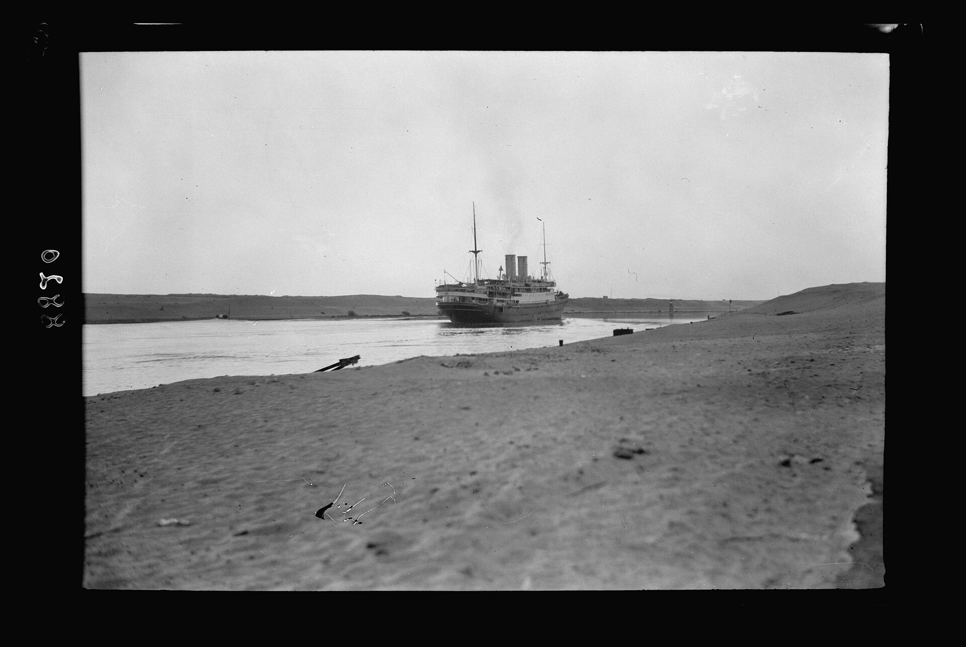 Historic black and white photograph of a steamship passing through the Suez Canal, Egypt