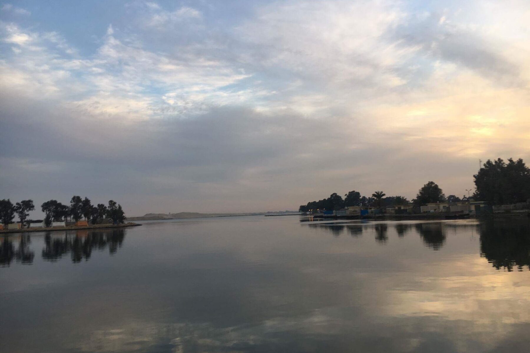 The Suez Canal at Ismailia, Egypt, under a cloudy sky at dawn