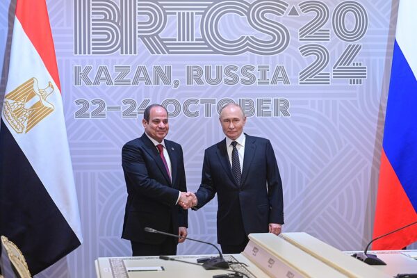 Egyptian President Abdel Fattah el-Sisi and Russian President Vladimir Putin shake hands in front of a BRICS 2024 backdrop in Kazan