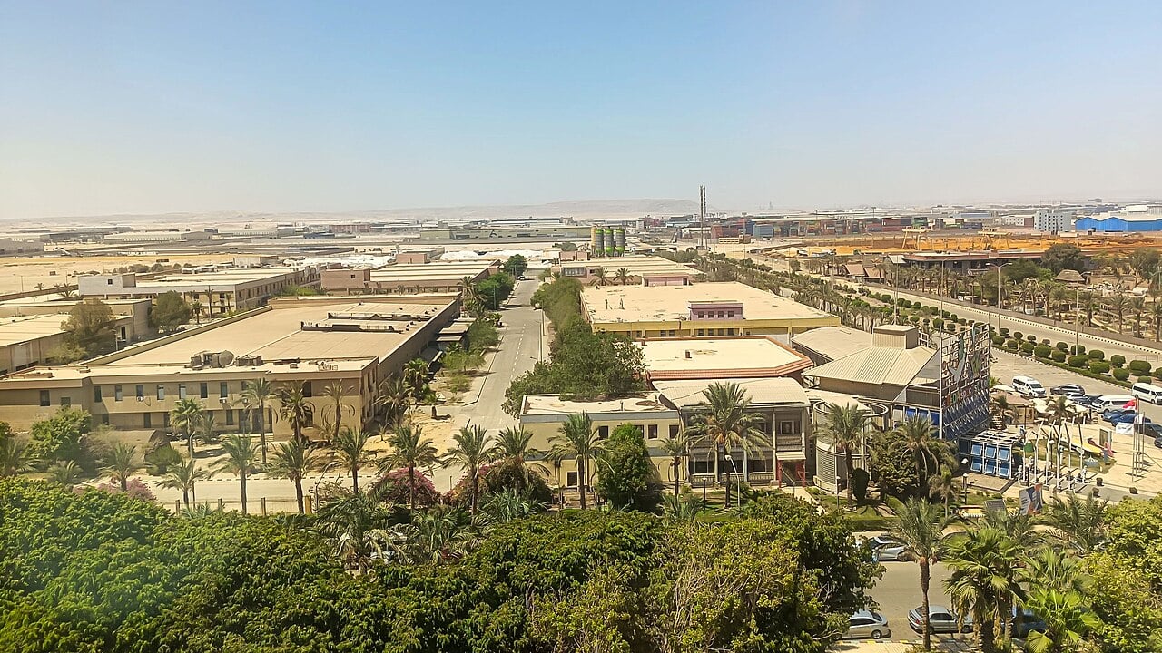 Aerial view of factory buildings, palm trees and a container port in the Ain Sokhna industrial zone, Egypt
