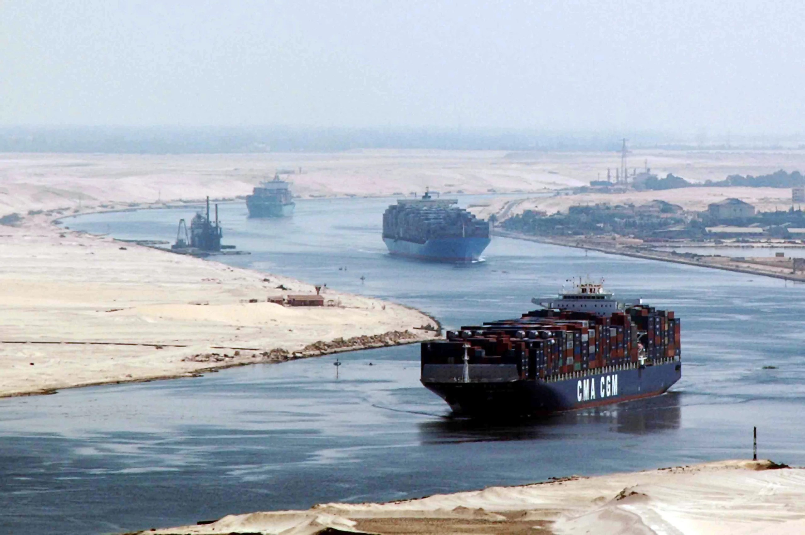 Container ships sailing through the Suez Canal between sand banks in Egypt