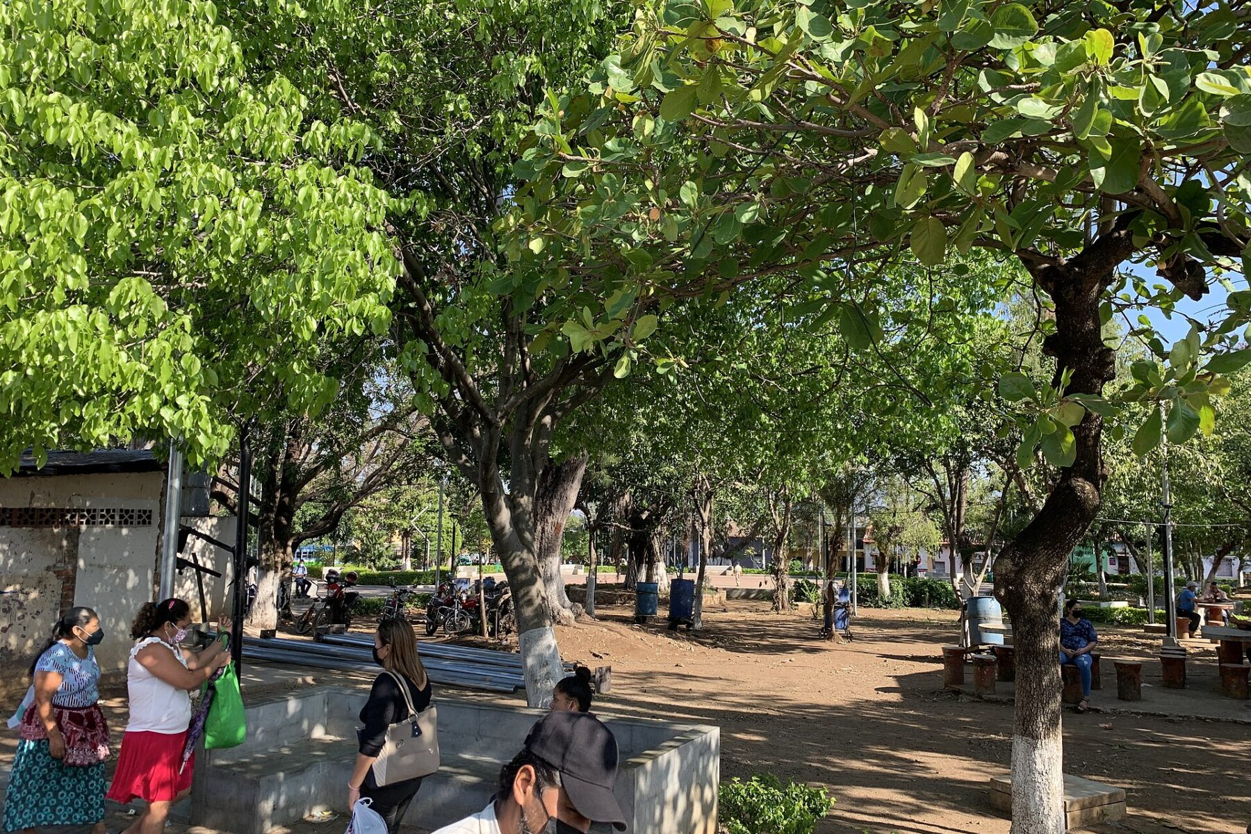 People walk through a tree-shaded public space in Atiquizaya, western El Salvador